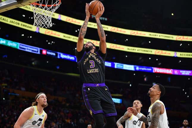 Nov 21, 2023; Los Angeles, California, USA; Los Angeles Lakers forward Anthony Davis (3) moves to the basket ahead of Utah Jazz forward John Collins (20) and forward Kelly Olynyk (41) during the first half at Crypto.com Arena.